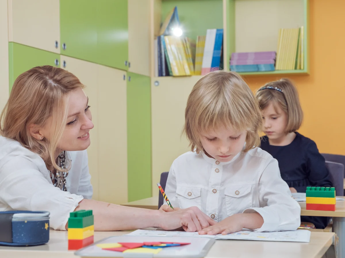 Учителька допомагає учневі на занятті